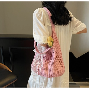 Detail of pink knitted shoulder bag with white lace trim and floral interior accents