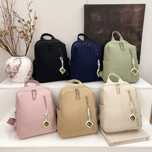 Close-up of lightweight nylon backpacks in six trendy colors displayed on tiered stands