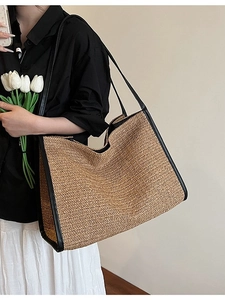 Large straw tote bag with black leather trim and handles for beach and daily commute
