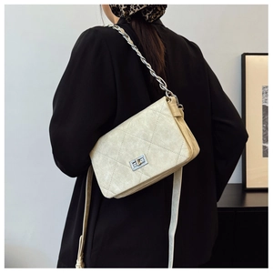 Quilted beige chain bag styled with a black blazer for a sophisticated commute look
