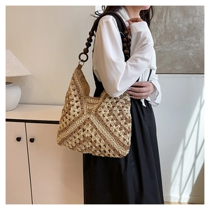Detail of hand-woven straw tote bag with brown wooden bead shoulder strap and geometric texture