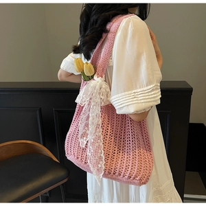 Detailed shot of pink woven knit bag featuring a large white lace bow and floral accent