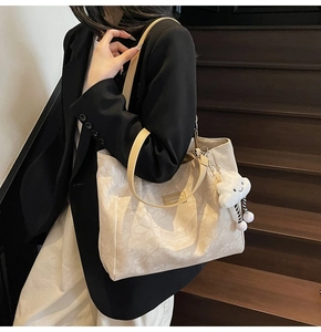 Vue détaillée d'un sac cabas beige avec anses jaunes et charm nuage en peluche doux