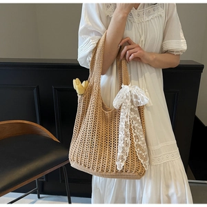 Detail of a beige woven tote bag featuring white lace bows and delicate floral accents