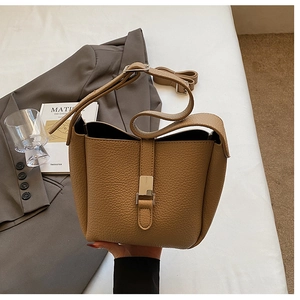 Détail du sac seau en cuir grainé avec finitions dorées et bandoulière réglable
