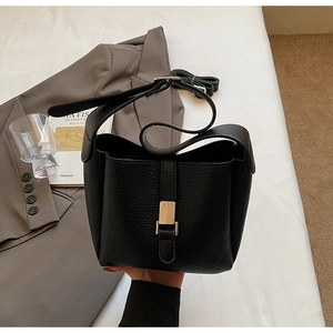 Détail du sac seau en cuir grainé noir avec fermoir magnétique en métal doré chic