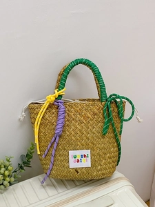 Handmade woven straw beach bag with vibrant striped rope handles and colorful tassels