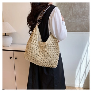Detail of woven straw shoulder bag featuring a vintage brown wooden bead strap design