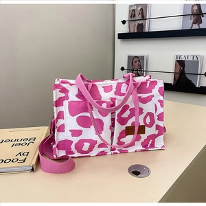 Macro detail of canvas tote bag showing pink leopard print and durable shoulder strap