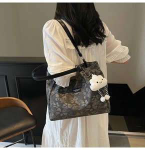 Détail du sac cabas vintage aux motifs floraux avec pendentif nuage blanc mignon