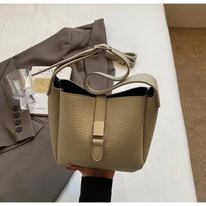 Détail du sac seau vert sauge en cuir grainé avec boucle en métal et bandoulière