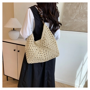 Detail of beige hollow woven shoulder bag with dark brown wooden beaded strap for summer