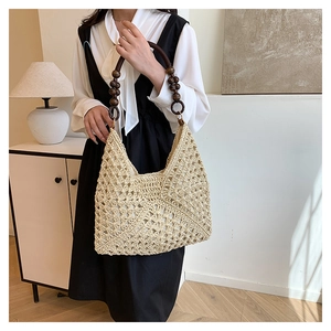 Detail of hand-woven beige straw tote bag featuring vintage wooden beaded handle for women