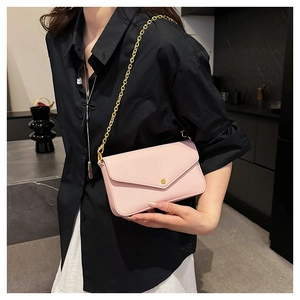 Close-up of pink envelope bag with pebble leather texture and gold chain strap