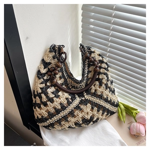 Detail of woven straw bag showing geometric pattern and dark wood bead handle