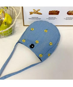 Gros plan détaillé d'un sac à bandoulière en jean bleu clair avec broderie de marguerites