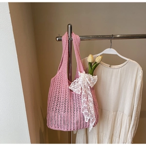 Close-up of pink woven tote bag featuring a white lace bow and yellow tulip decoration