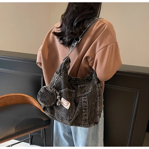 Détail du grand sac cabas en denim délavé avec poches extérieures et pochette ronde