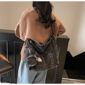Vue latérale du sac fourre-tout en denim délavé rétro avec bandoulière et mini porte-monnaie