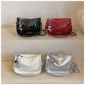 Close-up of four glossy crossbody bags in black, red, white, and silver with chain straps