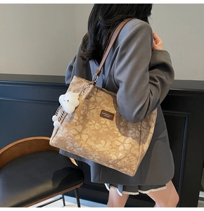 Détail d'un grand sac cabas à fleurs marron avec lanières en cuir et breloque nuage blanc