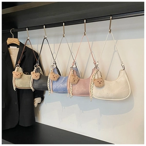Detail showing five colors of half-moon underarm bags with cute teddy bear charms