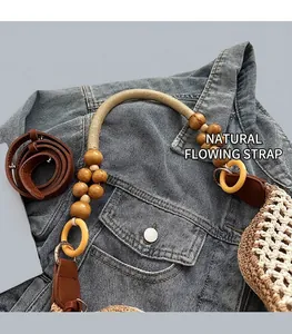 Detail of woven straw tote featuring yellow ring handle and adjustable leather strap