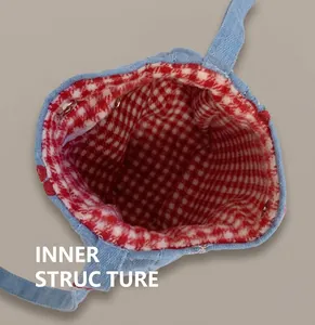Vue détaillée du sac en jean avec doublure à carreaux rouges et fermoir magnétique