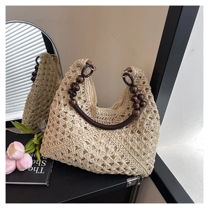 Detail of crochet straw tote featuring dark brown wooden bead handles and floral weave