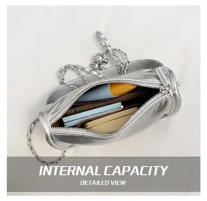 Internal view of silver cylindrical crossbody bag showing storage for phone and makeup