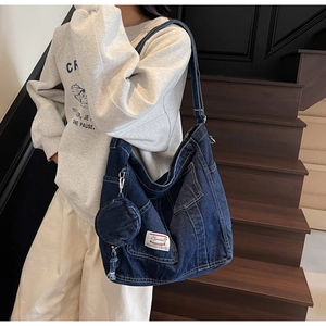Détail du grand sac cabas en denim bleu avec poche externe et petit porte-monnaie rond