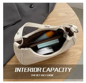 Detail view showing interior capacity of cream leather dumpling bag with daily essentials