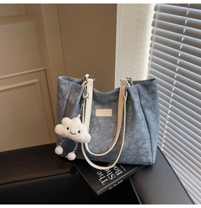 Détail du sac cabas floral bleu avec poignées blanches et charme en forme de nuage