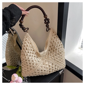 Detail of hand-crocheted straw shoulder bag with unique wooden beads on dark brown straps