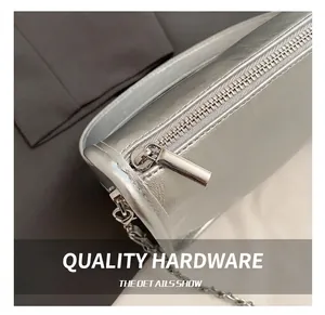 Close-up of premium silver metallic crossbody bag with textured leather and zipper detail