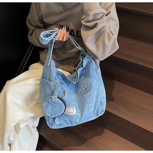 Détail du grand sac cabas en jean bleu avec porte-monnaie et finition délavée
