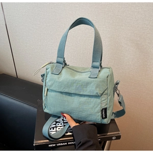 Détail du sac à main en nylon vert menthe avec bandoulière et poignées tissées