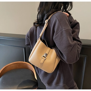 Détail d'un sac seau en cuir grainé avec boucle en métal argenté et bandoulière réglable