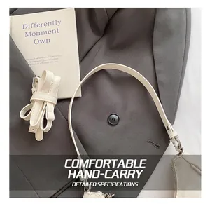 Detail of off-white leather shoulder bag with adjustable strap on suit background