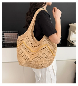 Gros plan d'un sac cabas en tricot beige avec motifs ondulés jaunes et texture ajourée