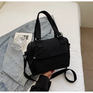 Detail of black nylon crossbody bag with wide webbing handles and adjustable strap