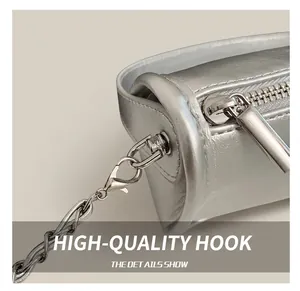 Detail of silver leather pillow bag showing metallic hooks and shiny chain strap texture