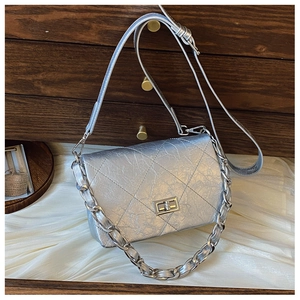 Detail of silver quilted flap bag with metallic leather texture and chain strap