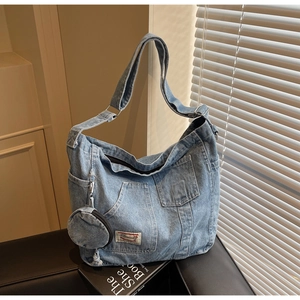 Détail du sac fourre-tout en denim bleu avec poches avant et porte-monnaie rond amovible