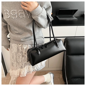 Detail of a black rectangular baguette bag with dual zippers and slim shoulder straps
