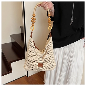 Detail of hand-woven tote bag with decorative wooden beads and premium leather strap
