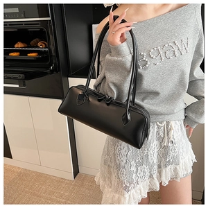 Detail view of the sleek black underarm bag with matte texture and dual shoulder straps
