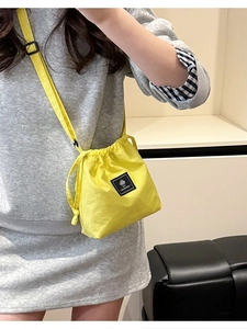 Vibrant yellow drawstring crossbody bucket bag in lightweight nylon for sporty leisure wear