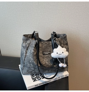 Détail du sac cabas gris foncé à fleurs avec anses en cuir et pendentif nuage