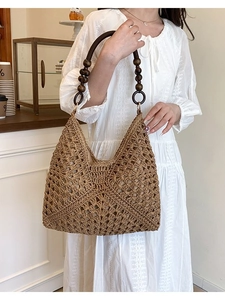 Handwoven straw tote bag with dark wood bead handles for beach vacation and casual commute